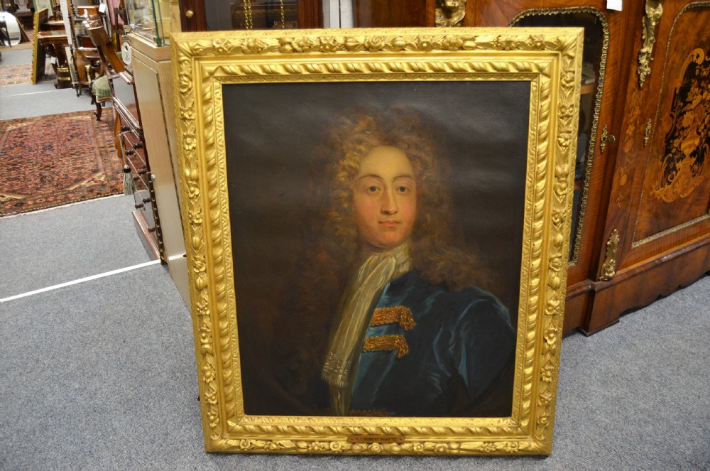 A pair of 19th-century oil portraits depicting male subjects in elaborate attire, enclosed within ornate, heavily carved gilt frames. View II
