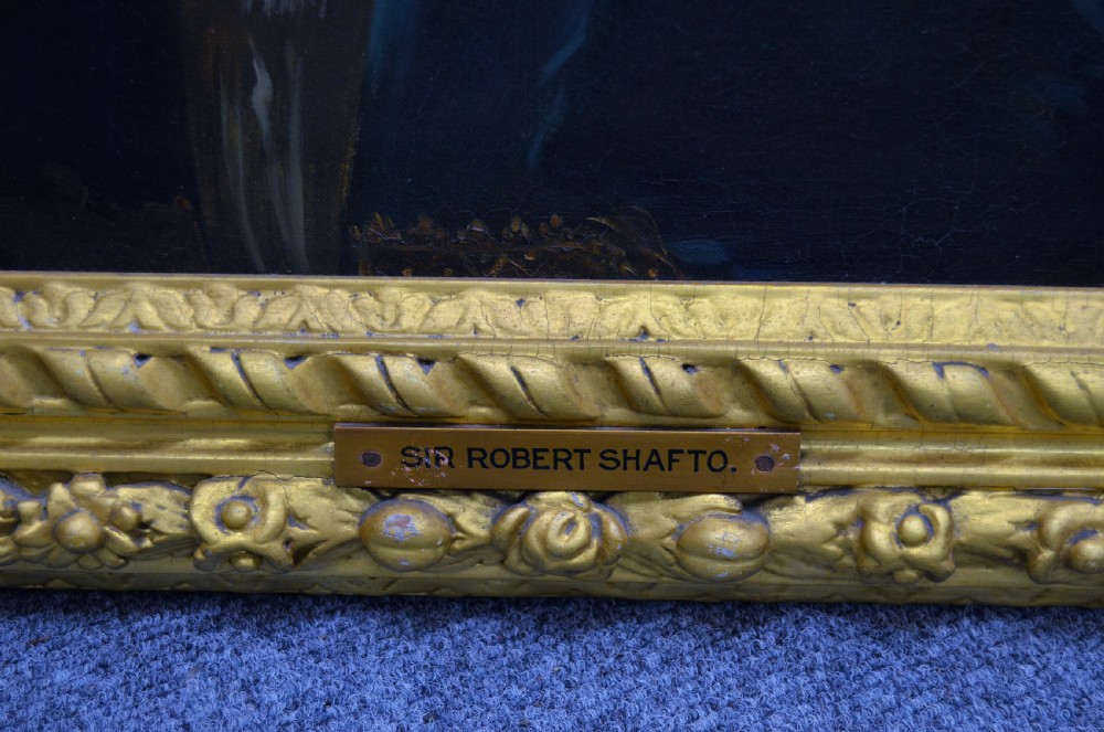 A pair of 19th-century oil portraits depicting male subjects in elaborate attire, enclosed within ornate, heavily carved gilt frames. View V