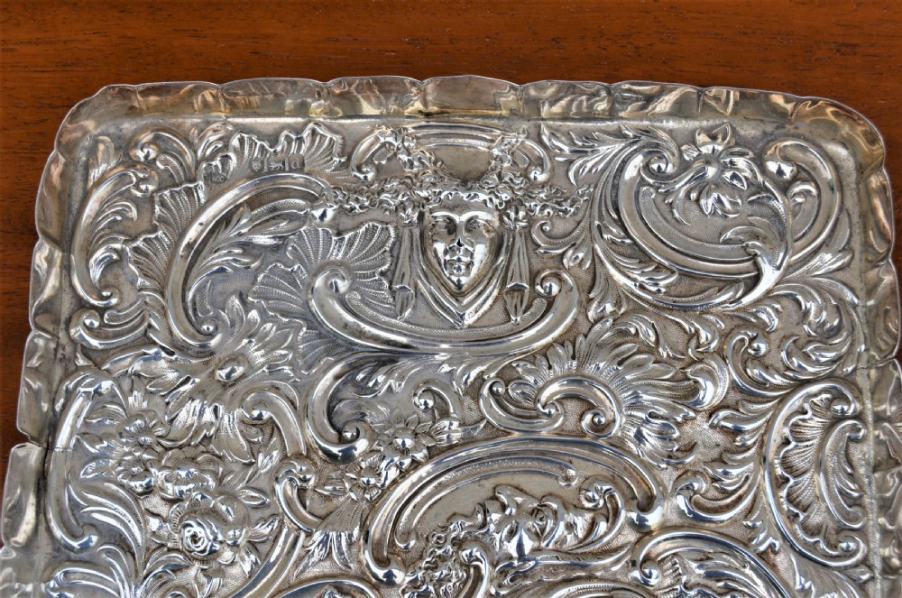 A rectangular sterling silver dressing table tray featuring detailed repousse scrollwork, foliate patterns, and a smooth central cartouche. View II