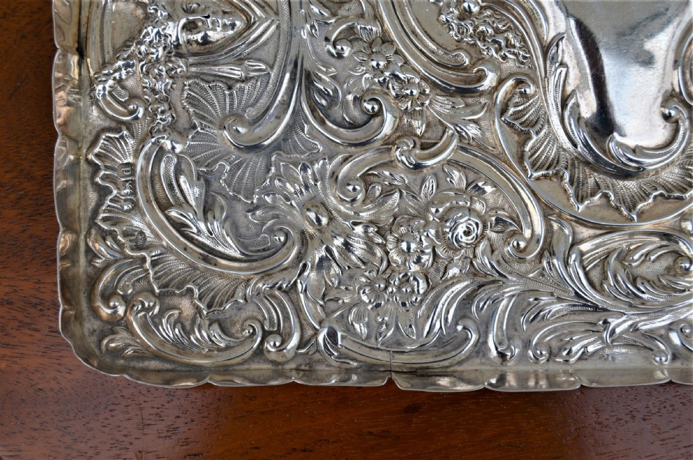 A rectangular sterling silver dressing table tray featuring detailed repousse scrollwork, foliate patterns, and a smooth central cartouche. View III