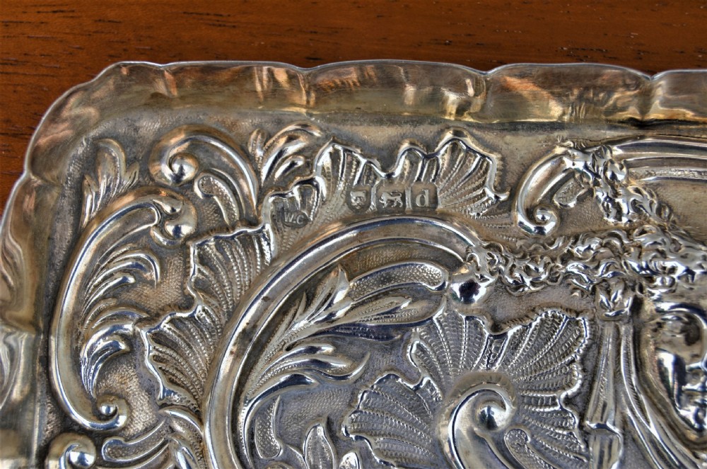A rectangular sterling silver dressing table tray featuring detailed repousse scrollwork, foliate patterns, and a smooth central cartouche. View V