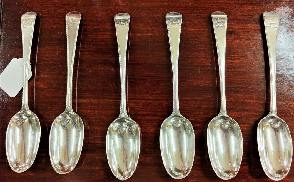 A set of six George III Irish sterling silver tablespoons in the Old English pattern, featuring bright-cut engraved edges and crests on the terminals.