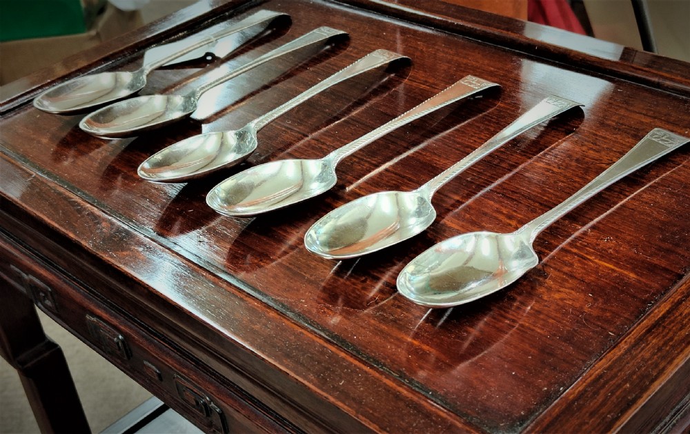 A set of six George III Irish sterling silver tablespoons in the Old English pattern, featuring bright-cut engraved edges and crests on the terminals. View III