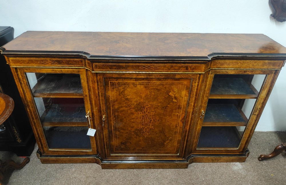 A Victorian burr walnut breakfront credenza featuring central marquetry inlay flanked by two glazed side cabinets.