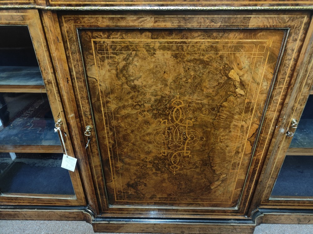 A Victorian burr walnut breakfront credenza featuring central marquetry inlay flanked by two glazed side cabinets. View IV