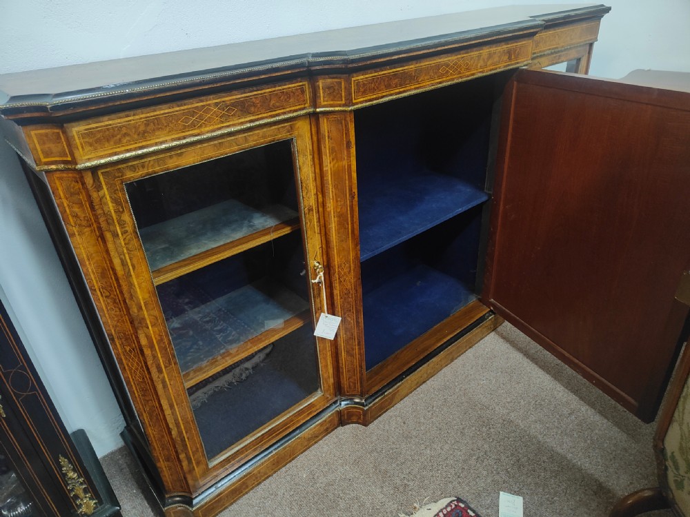 A Victorian burr walnut breakfront credenza featuring central marquetry inlay flanked by two glazed side cabinets. View VI