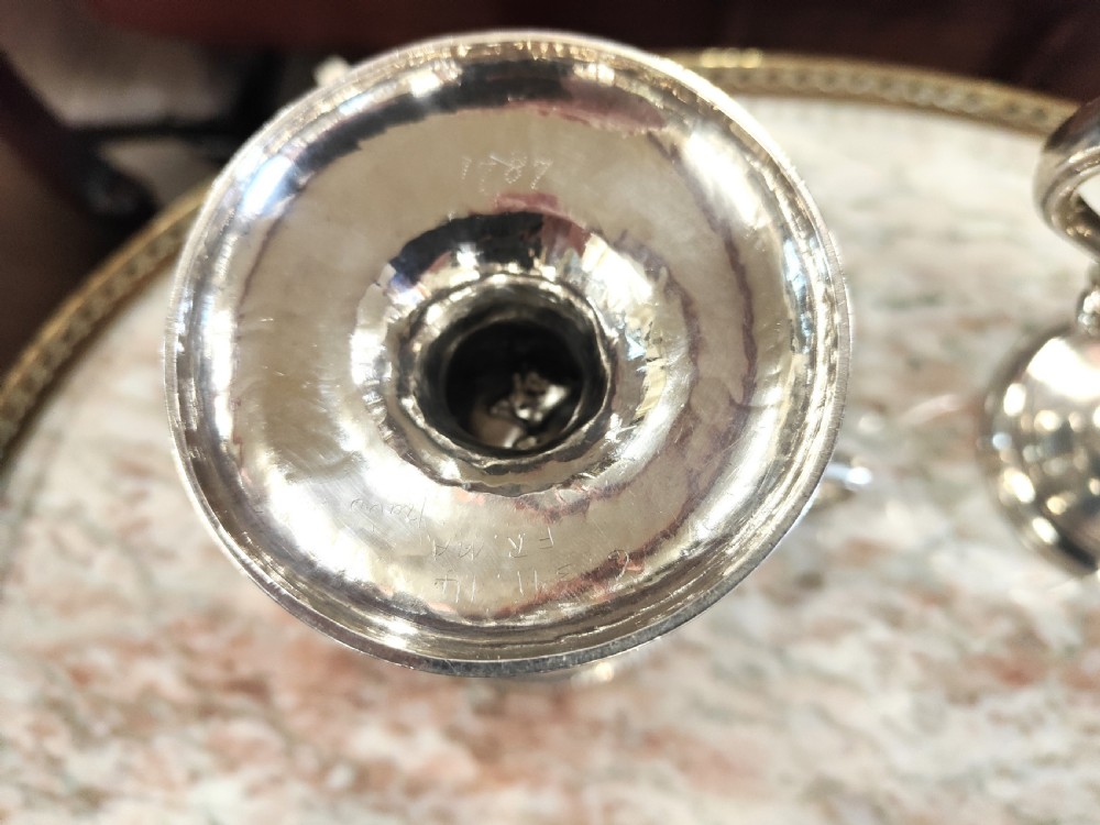 A pair of 18th-century Irish sterling silver twin-handled cups featuring central ribbed girdles and engraved crests on pedestal bases. View VI