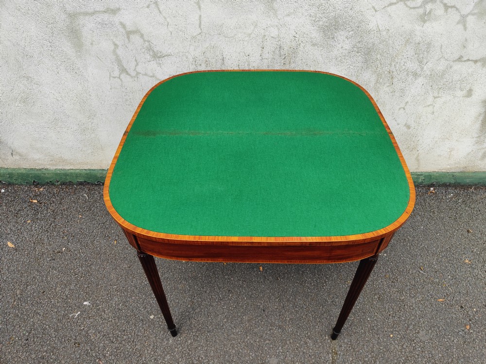 A Georgian mahogany demilune card table featuring satinwood crossbanding along the folded top and fluted tapered legs. View IV