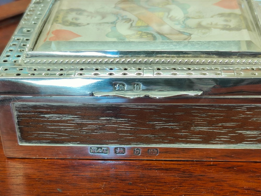 A rectangular late Victorian sterling silver cribbage box featuring a central glazed Queen of Hearts playing card surrounded by a pegboard border. View II