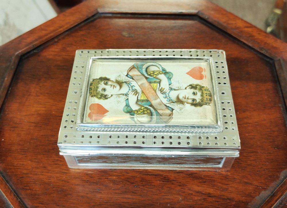 A rectangular late Victorian sterling silver cribbage box featuring a central glazed Queen of Hearts playing card surrounded by a pegboard border. View IV