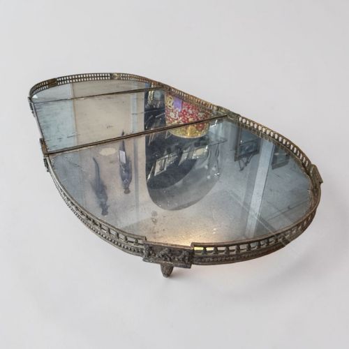 fig 1. A 19th-century French silvered metal table centrepiece featuring a three-section oval mirrored base surrounded by a pierced gallery border.