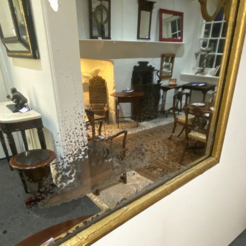 fig 1. A tall rectangular 19th-century French Neoclassical wall mirror featuring a narrow gilded wooden frame and aged mirror glass.