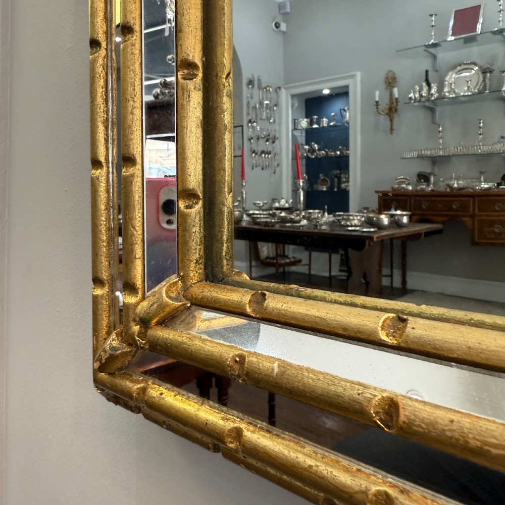 An early 20th-century tall rectangular Italian wall mirror featuring a gilt frame with panelled mirrored borders and faux bamboo detailing. View II