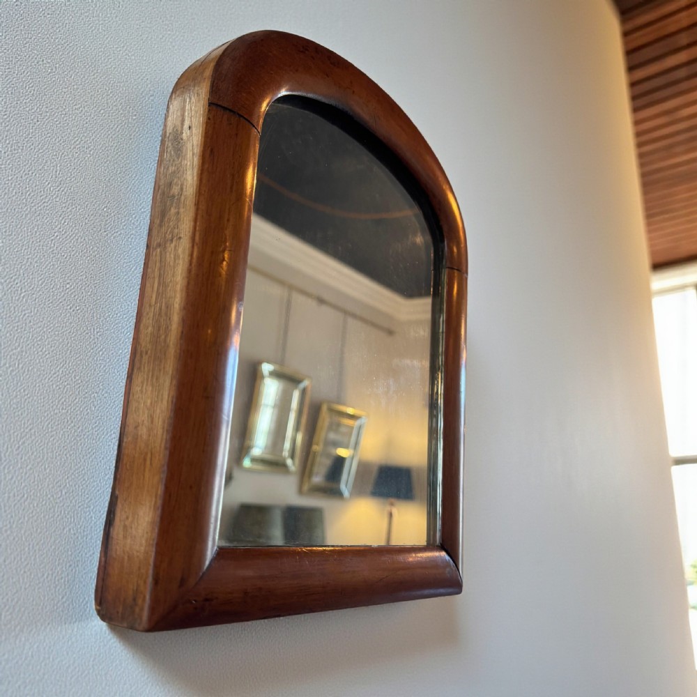 A Victorian wall mirror featuring an arched frame crafted from dark mahogany timber. View II