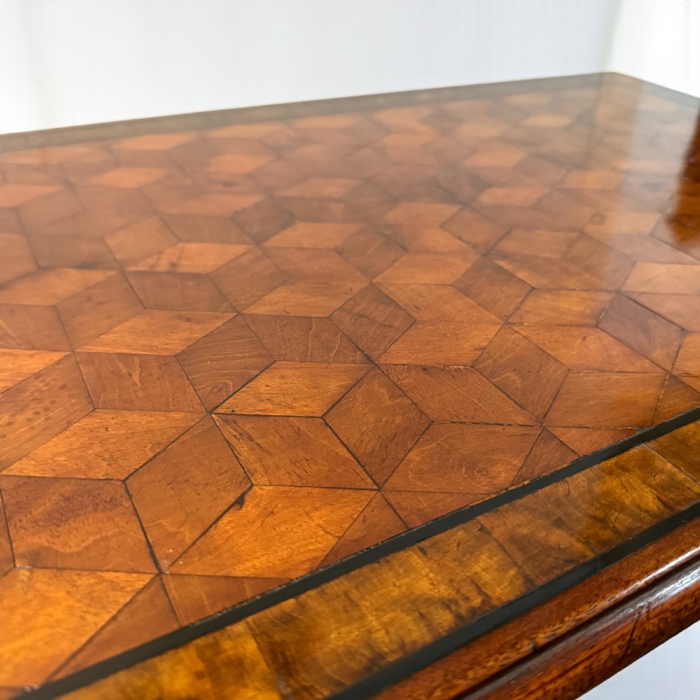 An Edwardian rectangular walnut side table featuring a geometric parquetry top with crossbanded borders and slender square tapered legs. View II