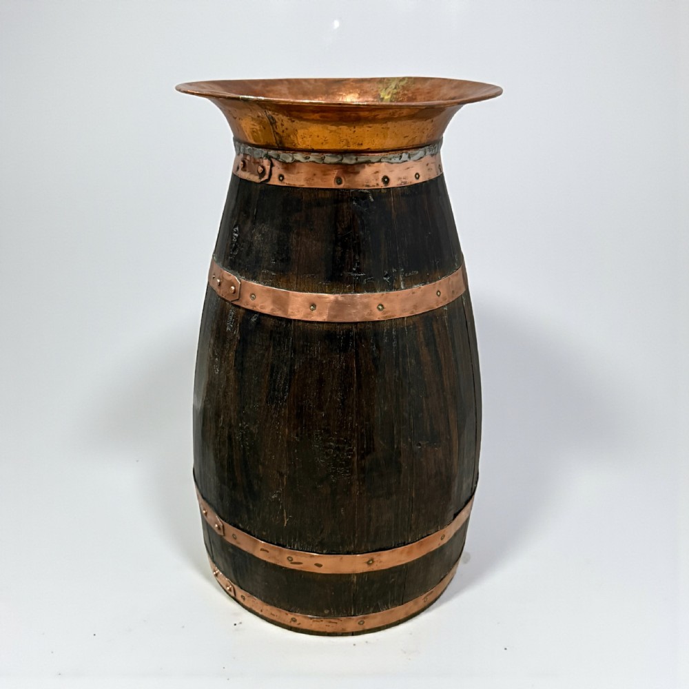 A coopered dark wood barrel stick stand featuring broad riveted copper binding bands and a flared copper top rim. View II