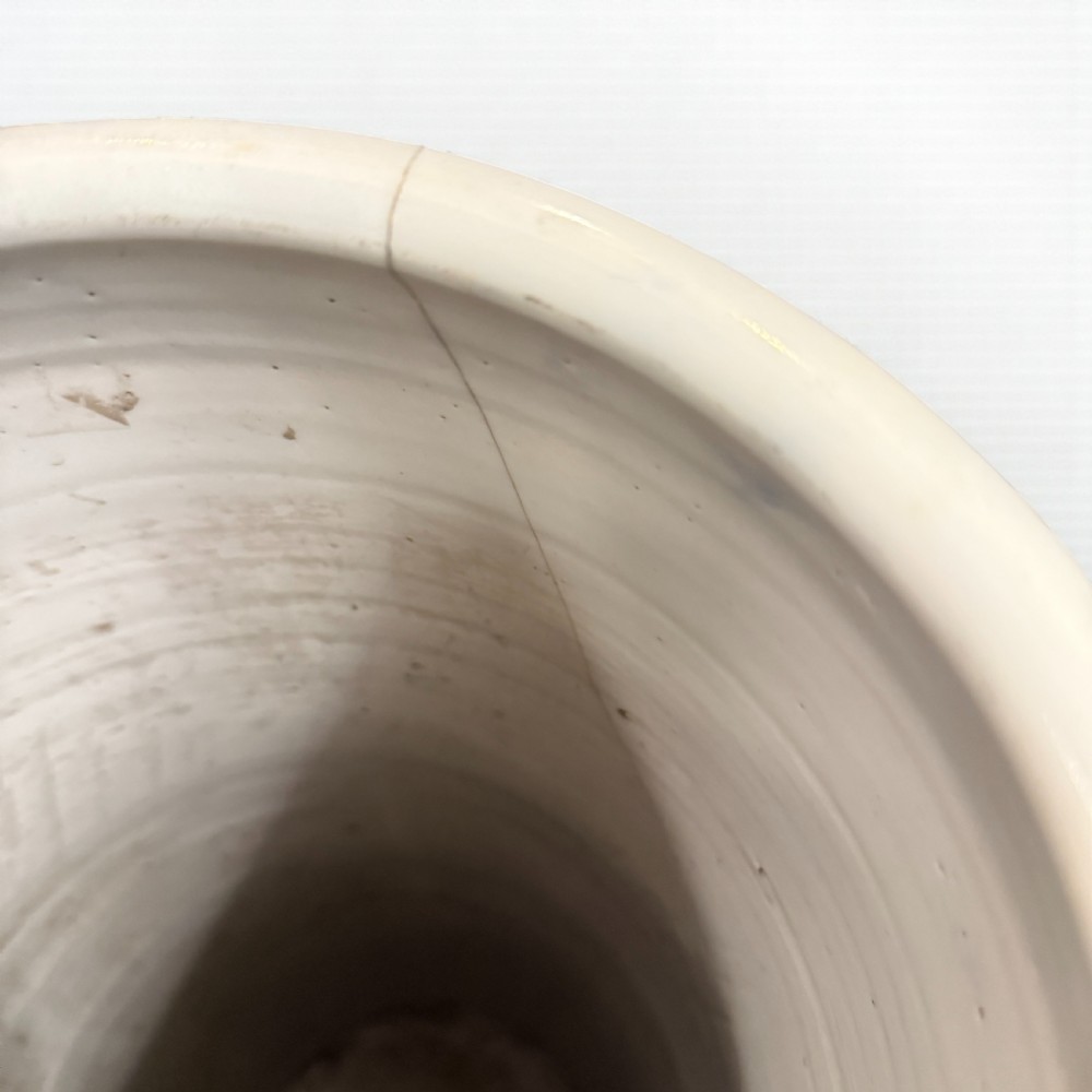 A tall cylindrical ceramic stick stand decorated in underglaze blue with a central crane, bamboo stalks, and floral borders against a white background. View II