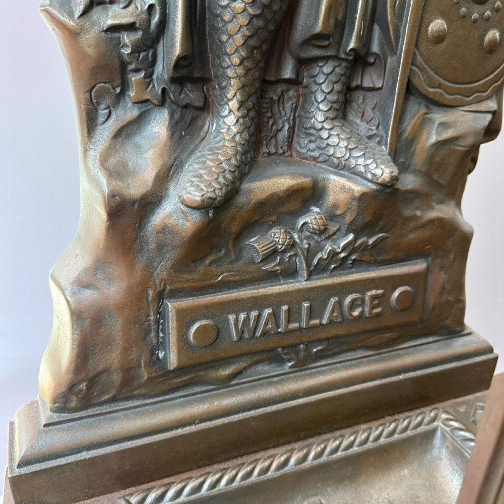 A Victorian cast iron stick stand featuring a relief figure of William Wallace in full armour with a sword, shield, upper retaining framework, and lower drip tray. View III
