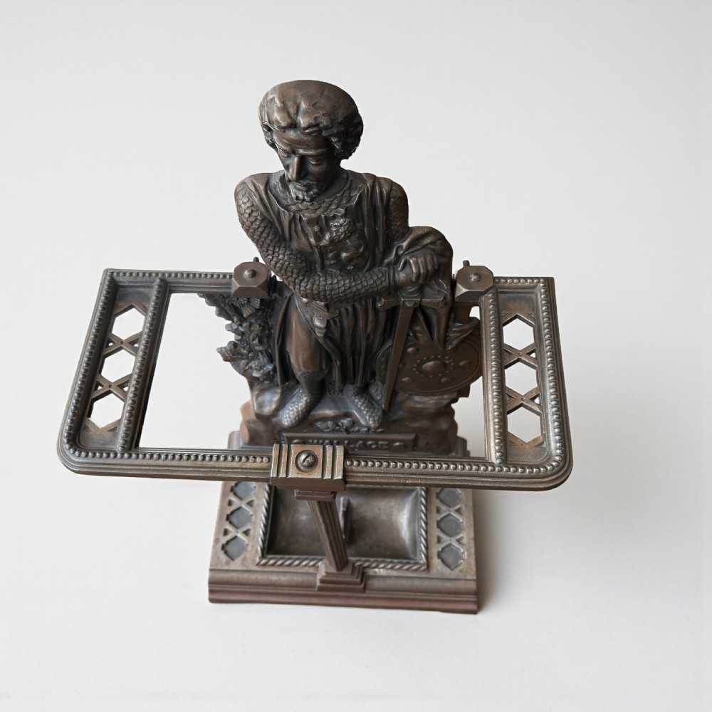A Victorian cast iron stick stand featuring a relief figure of William Wallace in full armour with a sword, shield, upper retaining framework, and lower drip tray. View V