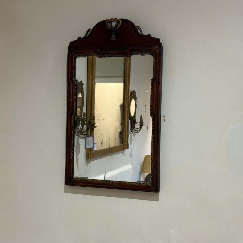 A dark mahogany wall mirror with carved fretwork scroll edging, a shaped pediment top, and a gild slip border around the reflective glass. View II