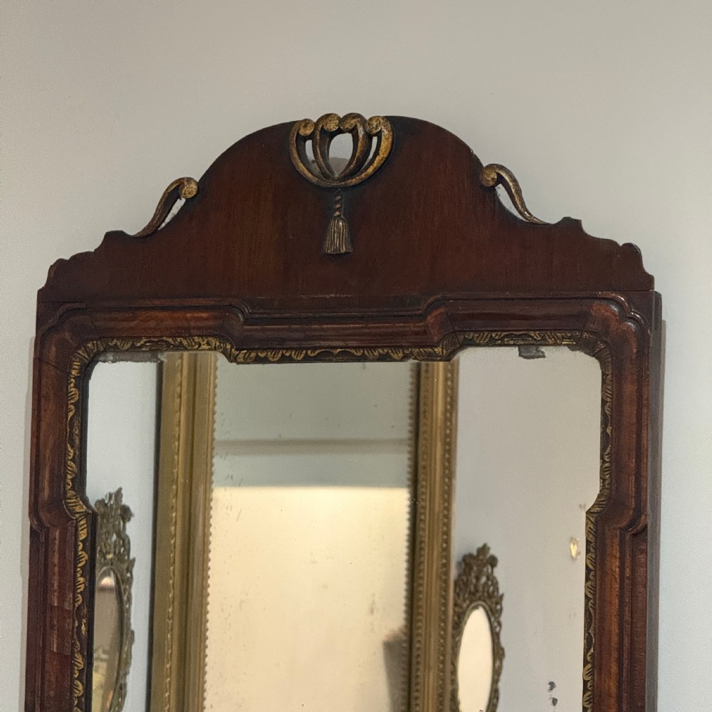A dark mahogany wall mirror with carved fretwork scroll edging, a shaped pediment top, and a gild slip border around the reflective glass. View III