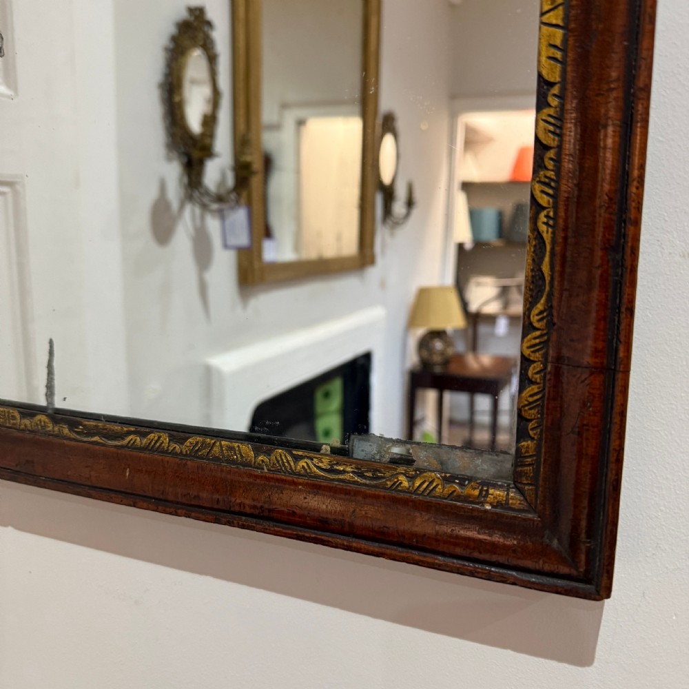 A dark mahogany wall mirror with carved fretwork scroll edging, a shaped pediment top, and a gild slip border around the reflective glass. View IV