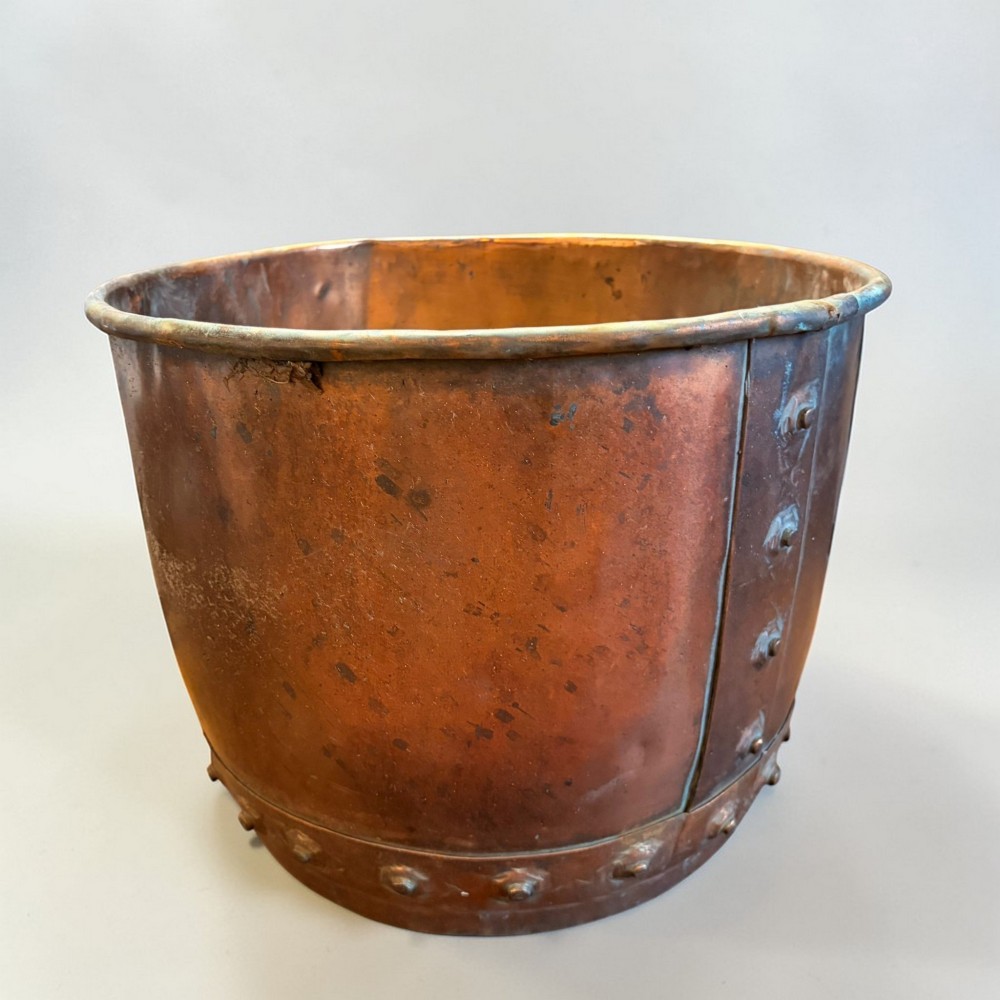 A late 19th-century cylindrical copper vessel featuring hand-riveted seams and a rolled rim.