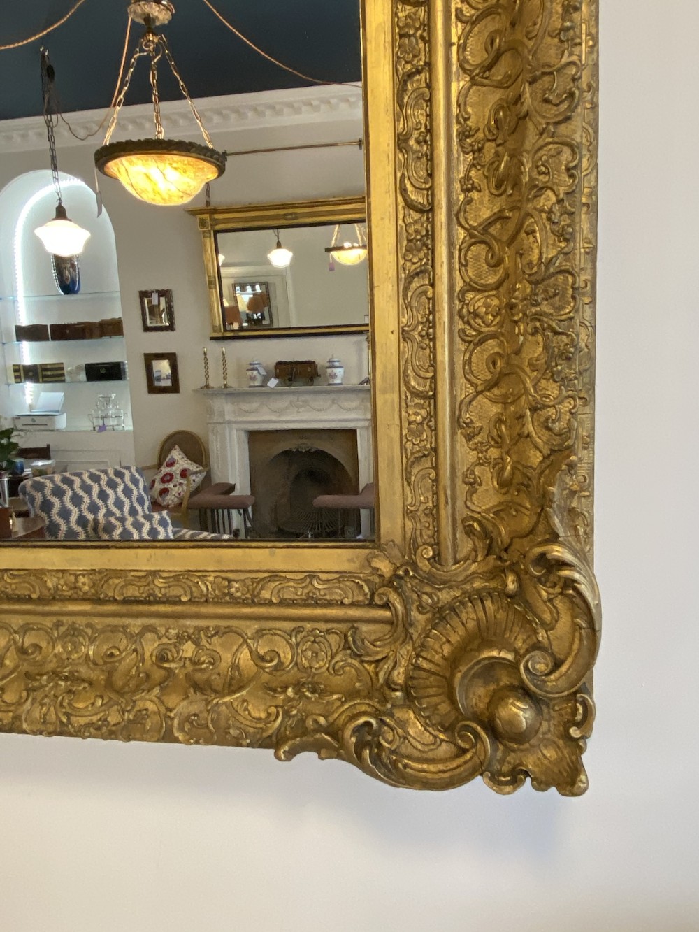 A large rectangular 19th-century wall mirror featuring an ornate gilded frame with carved acanthus leaf corner mouldings. View II