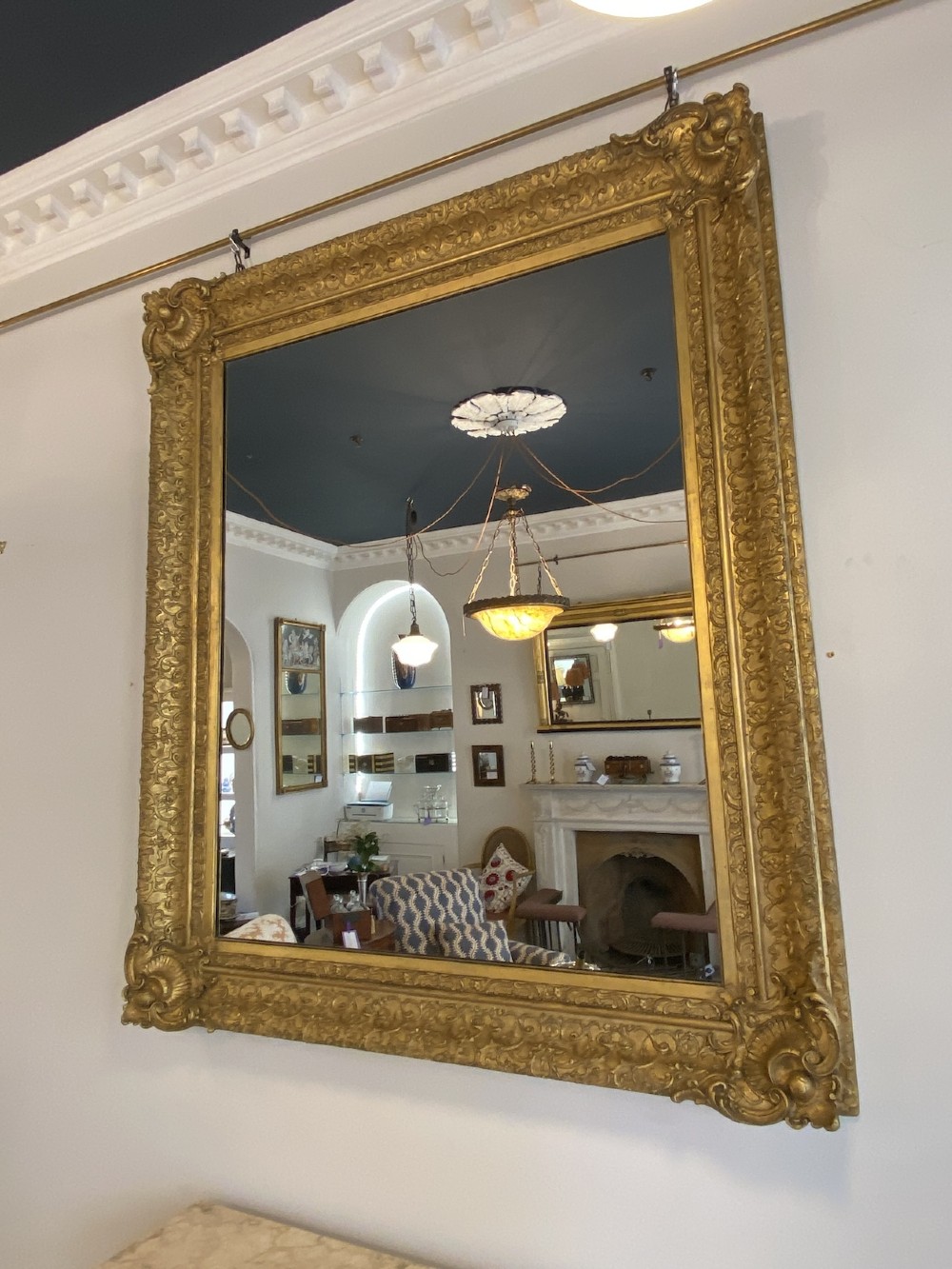 A large rectangular 19th-century wall mirror featuring an ornate gilded frame with carved acanthus leaf corner mouldings. View IV