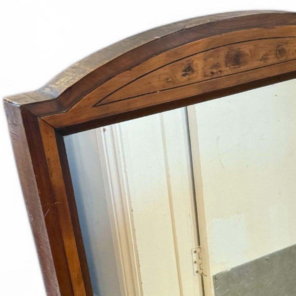 A rectangular antique wooden wall mirror featuring a gently arched top frame detailed with walnut, yew, and mahogany veneers. View II