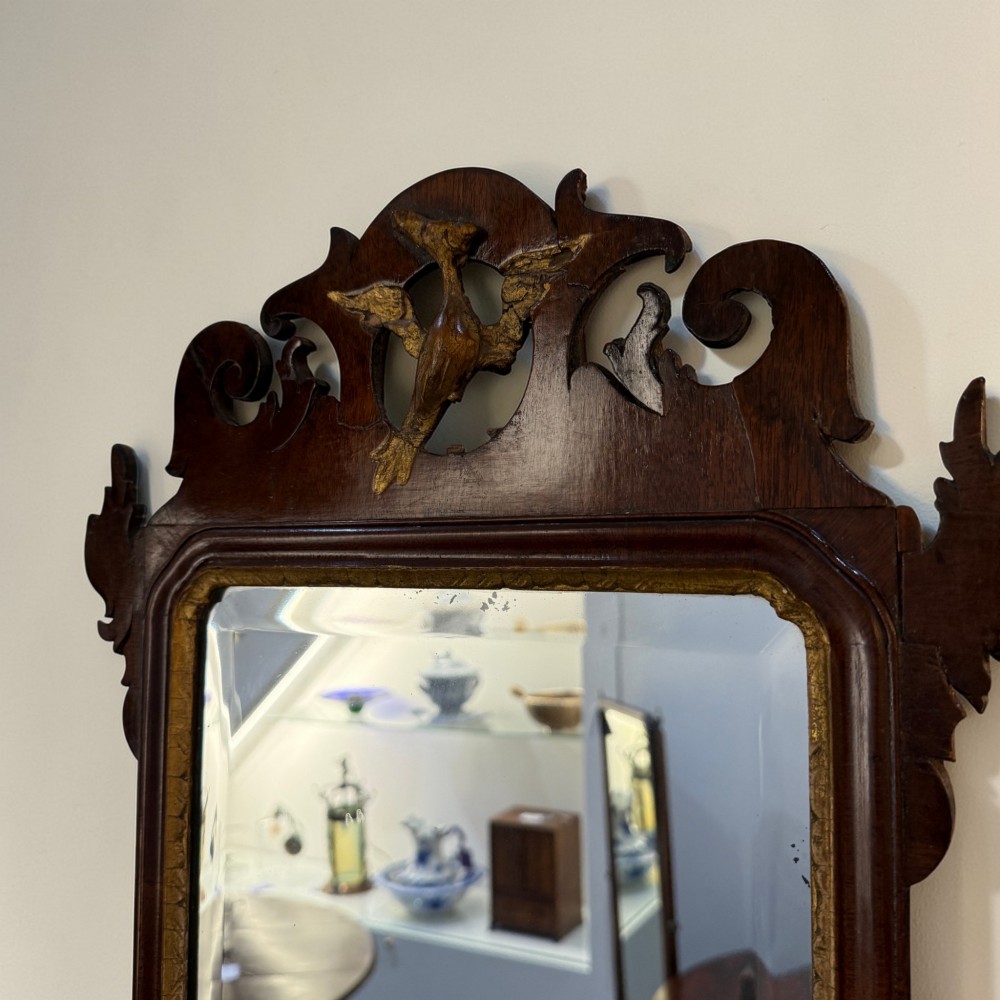 A vertical Chippendale style mahogany wall mirror featuring cut-out fretwork scrolling, a gilded bird motif at the crest, and a rectangular mirror plate with a gilt slip. View II