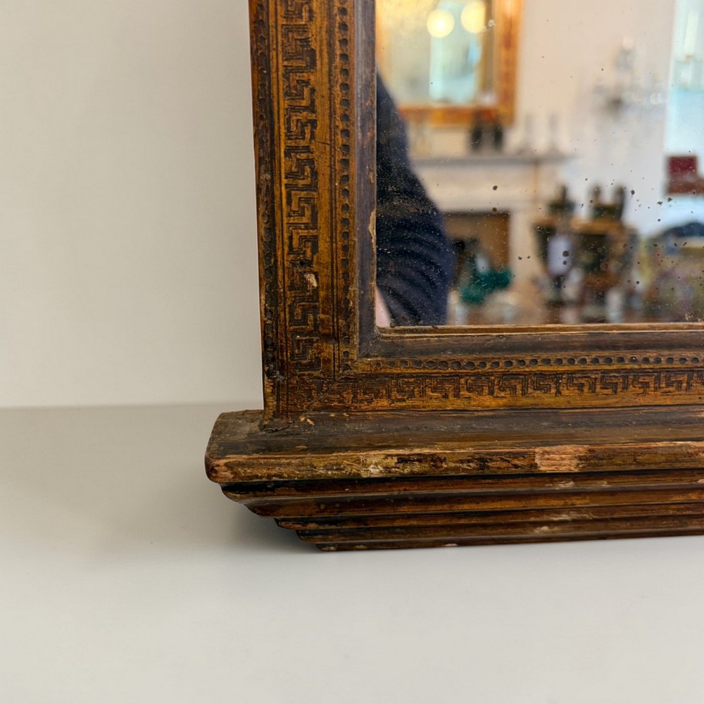 A nineteenth-century Neoclassical rectangular wall mirror featuring an architectural cornice, dentil moulding, carved Greek key border details, and foxed glass. View II