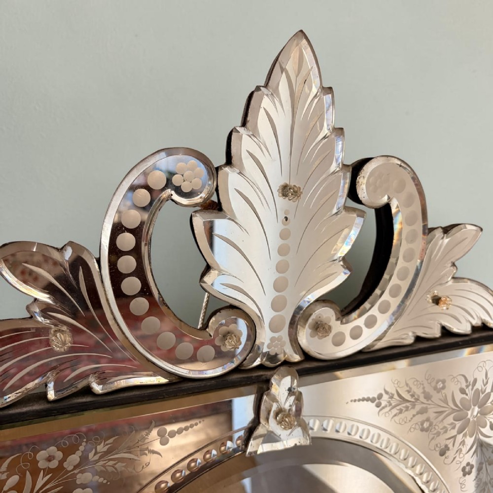 A rectangular Venetian wall mirror featuring etched floral border panels, a central oval mirror aperture, and a glass foliate crest at the top. View II