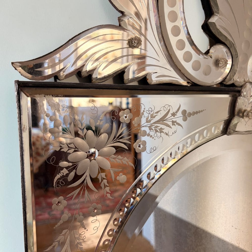 A rectangular Venetian wall mirror featuring etched floral border panels, a central oval mirror aperture, and a glass foliate crest at the top. View III