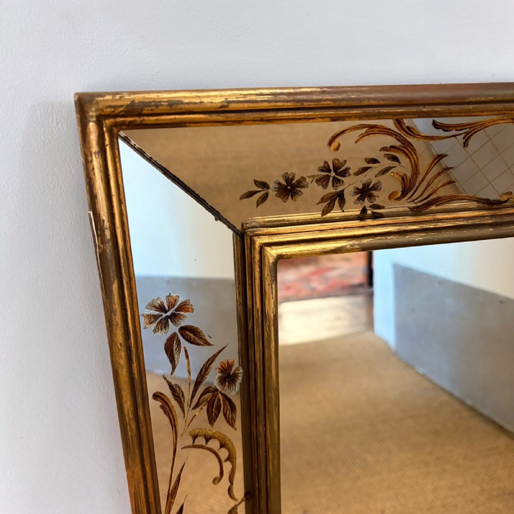 A rectangular wall mirror featuring a slender gilt frame surrounding a secondary reverse-painted eglomise border depicting Chinoiserie figures and floral motifs. View II