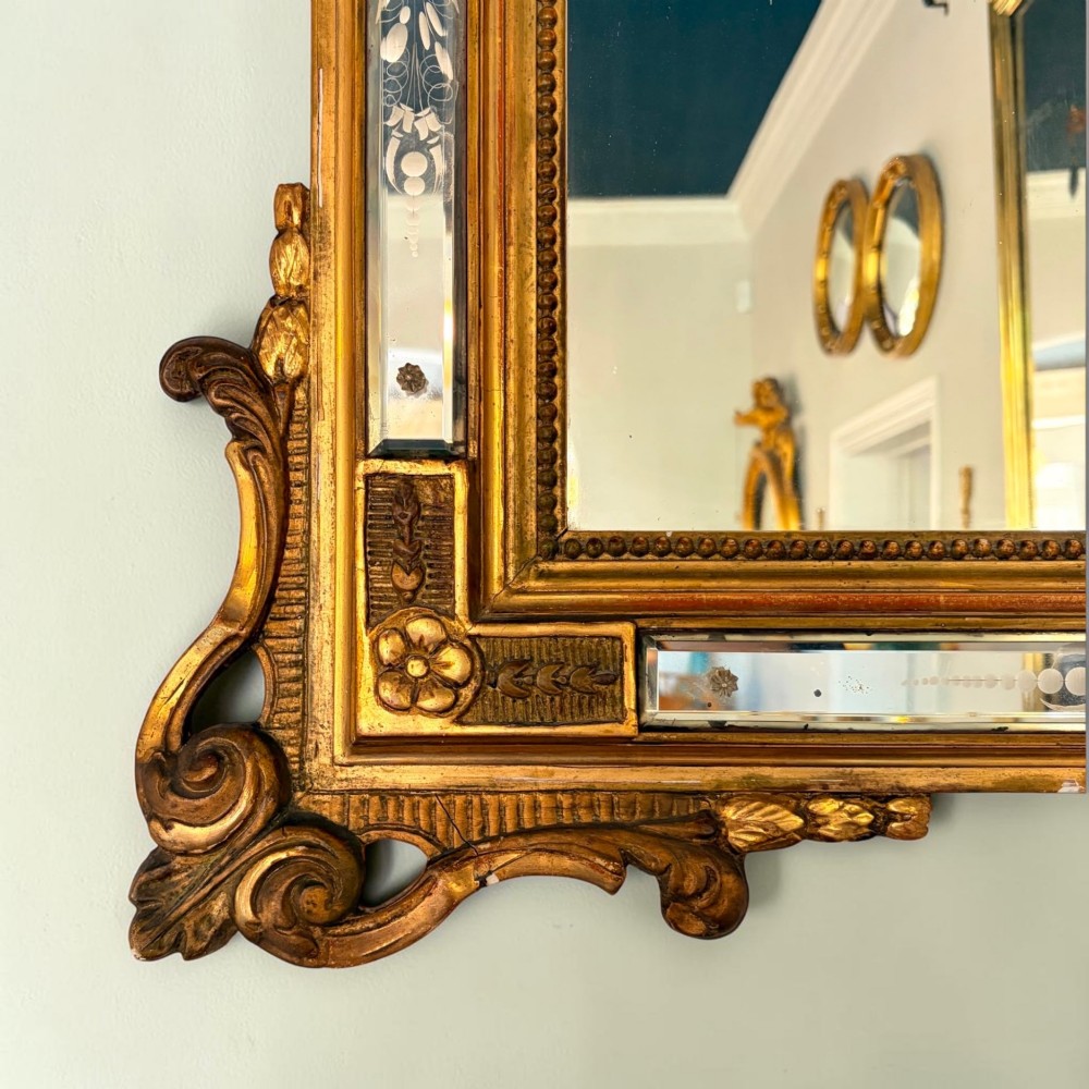 A rectangular French giltwood wall mirror featuring an ornate carved cresting, floral etched glass border panels, and a central mirror plate. View III