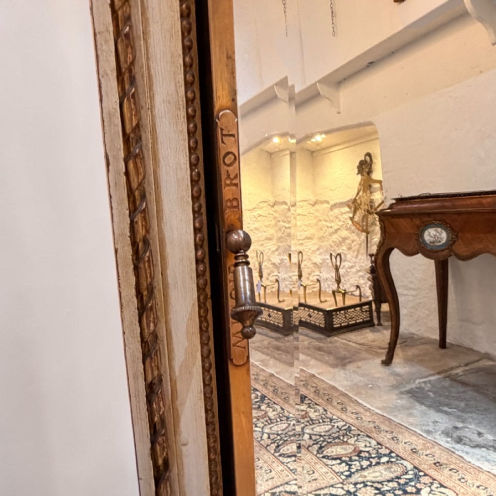 A large French giltwood triptych mirror featuring a ribbon-carved crest and three hinged folding mirror panels. View II