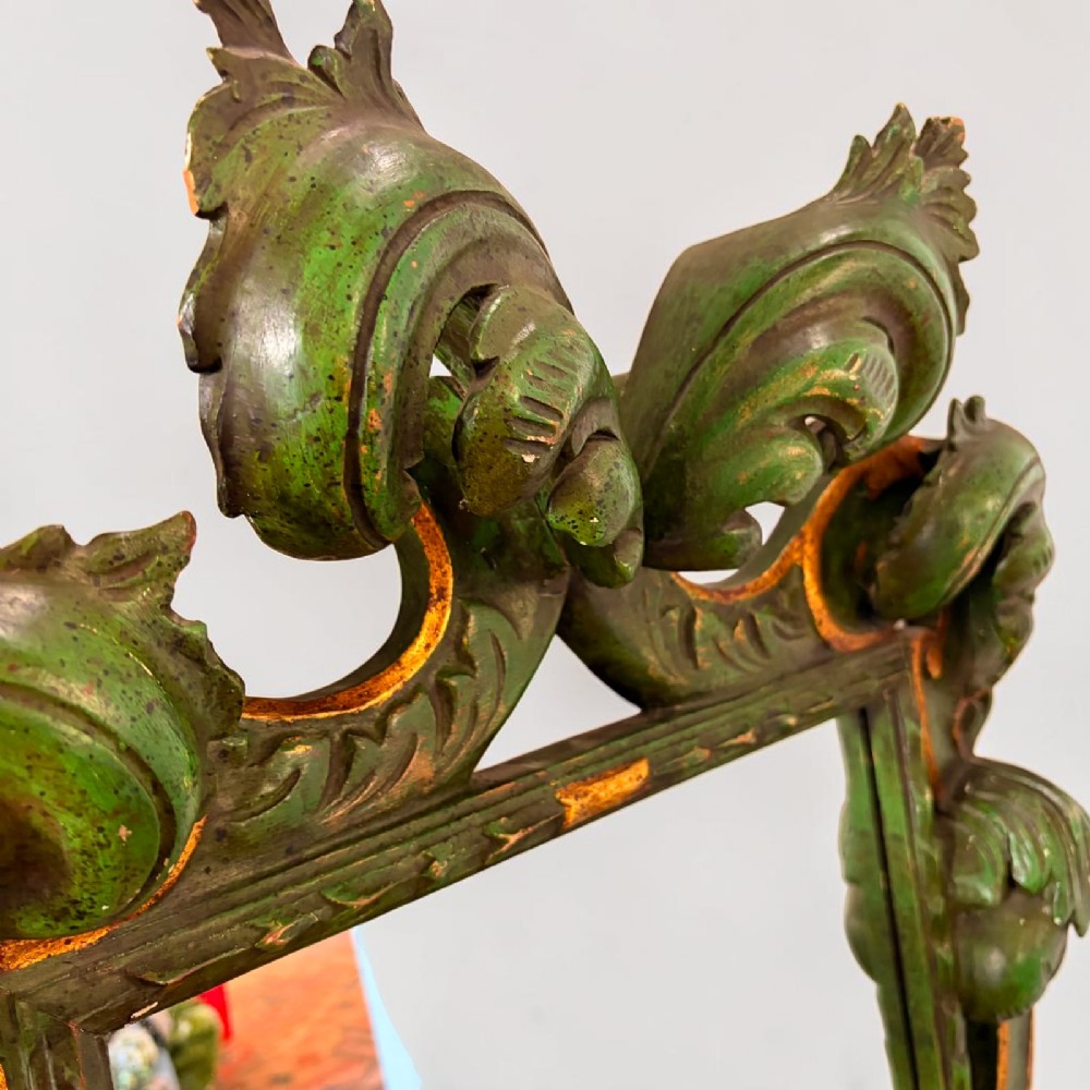 An ornate Italian Florentine style carved wooden mirror painted in olive green with gold leaf accents along scrolled acanthus leaf borders. View III