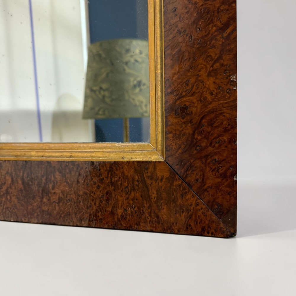 A 19th-century rectangular wall mirror featuring a wide burr walnut veneer frame with a gilded inner slip moulding. View II