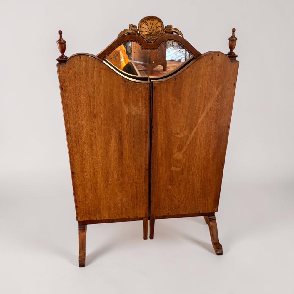 An Edwardian mahogany tri-fold dressing mirror featuring an arched central frame with a carved shell cresting and adjustable side panels. View II