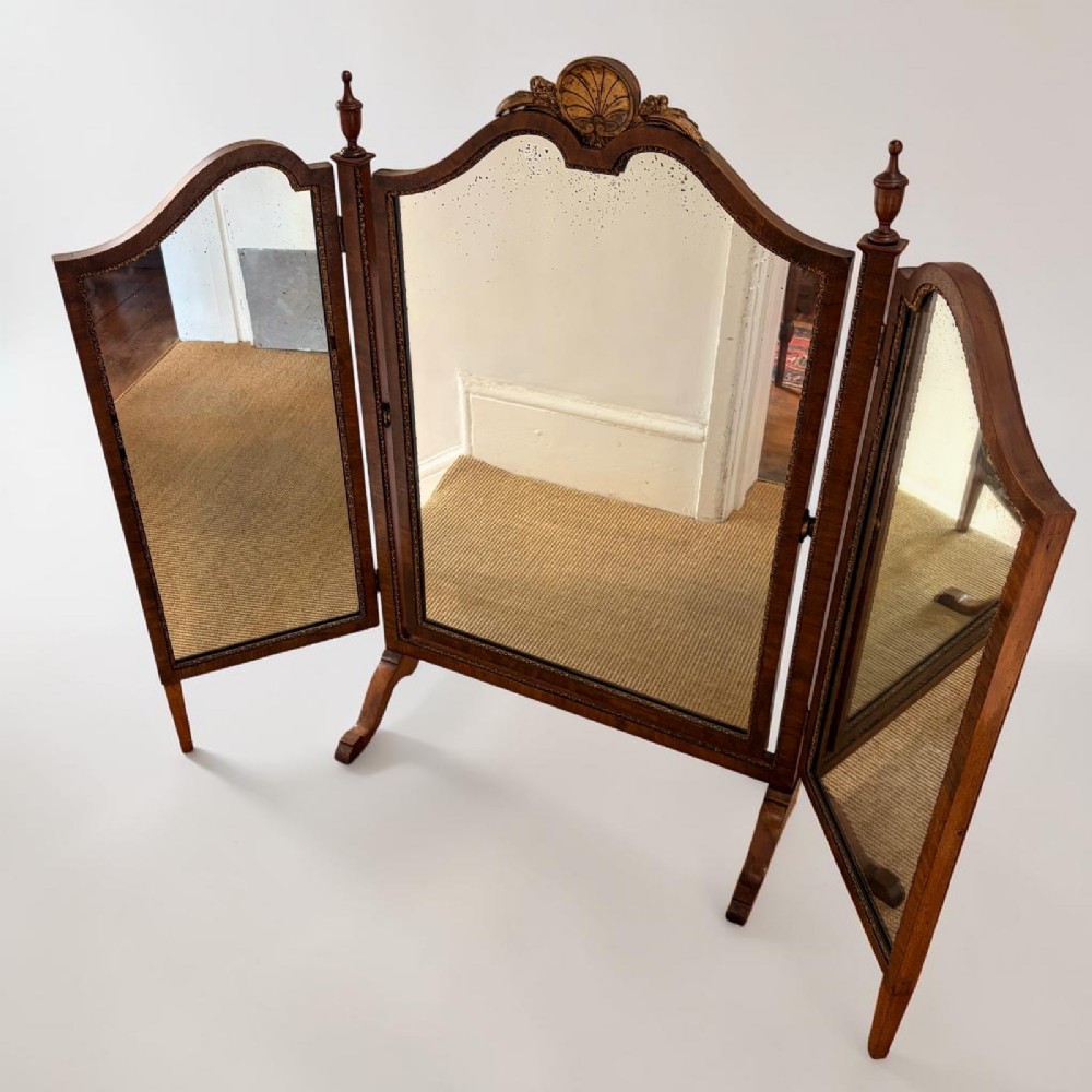 An Edwardian mahogany tri-fold dressing mirror featuring an arched central frame with a carved shell cresting and adjustable side panels. View IV
