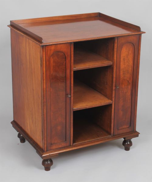 Mahogany Library Cabinet with Two Cupboards, Each with a Removable Shelf and a Second Section with Two Removable Shelves.  the Top with a Three-quarter Gallery, the Doors of Arcaded Form with Figured Mahogany Panels, Standing on Turned Peg Feet.  Circa 1825

27” (68.5cm) Wide, 19 ¾” (53cm) Deep and 31” (79cm) High (32 ½”/82.5cm High to Gallery)
