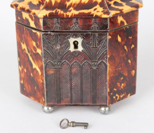 fig 1. A pair of octagonal George IV period miniature tea caddies crafted with mottled tortoiseshell veneer, silver urn finials, ball feet, and gothic arcading.