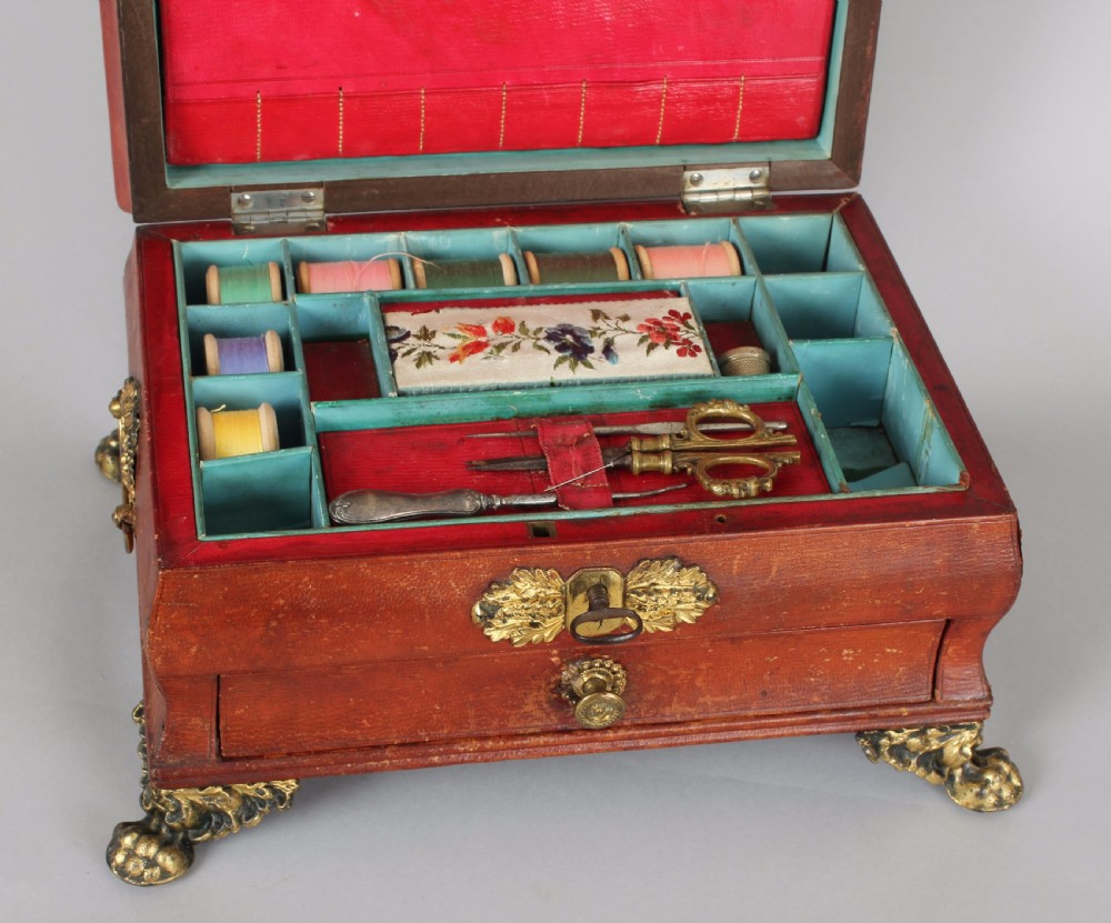 A Regency period sarcophagus-form work-box bound in red Russia leather with gilt-brass paw feet, side handles, and escutcheon. View III