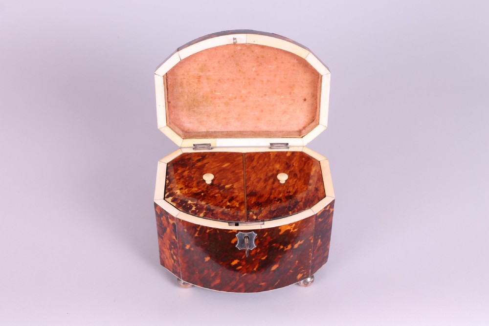 A Regency period bow-fronted tea caddy made from amber and brown tortoiseshell with a silver lid plate, escutcheon, and key. View V