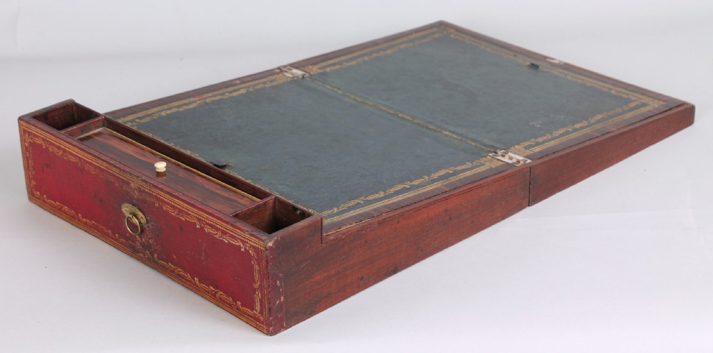 An early nineteenth-century table-cabinet bound in deep red tooled leather, featuring fluted column corner posts, classical gilt-brass figure mounts on the twin doors, and dolphin side handles. View VII