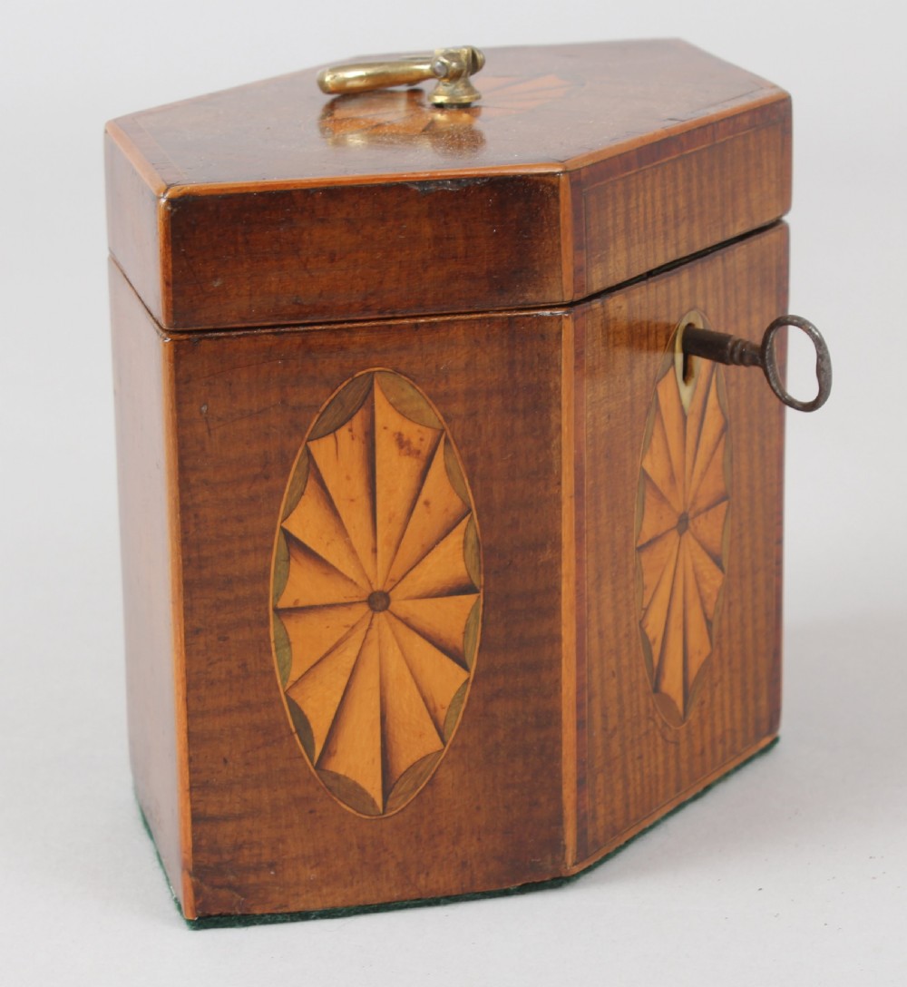 A George III hexagonal harewood tea caddy featuring oval fan marquetry motifs on its sides and top lid with a brass loop handle. View II