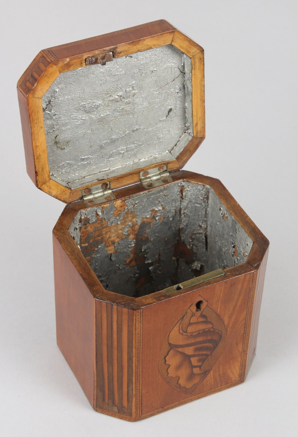 An octagonal George III satinwood tea caddy featuring a hinged lid, inlaid shell marquetry, geometric stringing, and a keyhole escutcheon. View IV