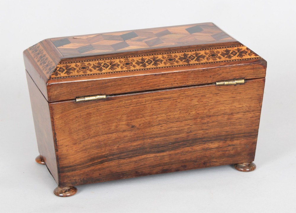 An antique rosewood tea caddy featuring geometric parquetry on the lid, detailed floral mosaic borders, a keyhole, and turned feet. View II