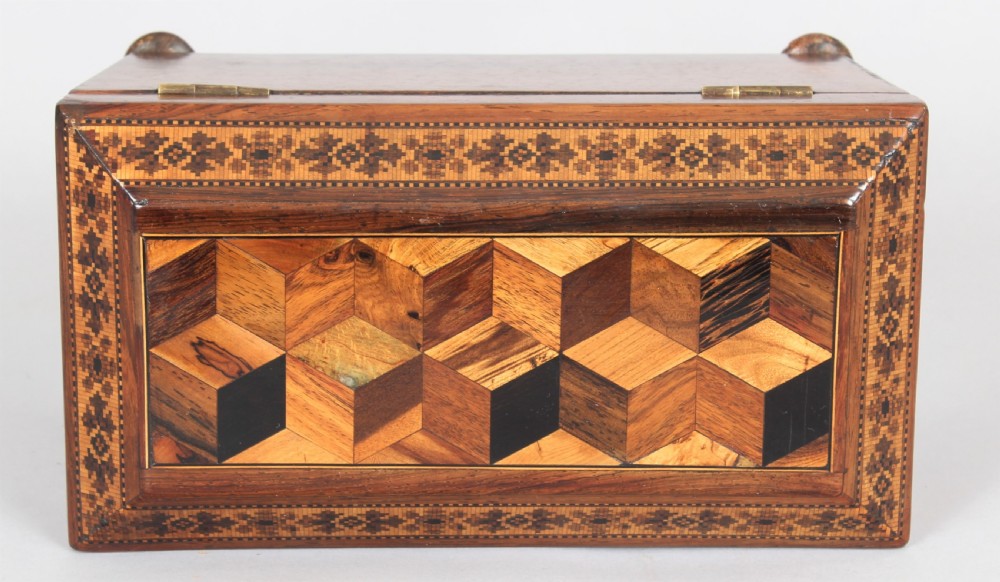 An antique rosewood tea caddy featuring geometric parquetry on the lid, detailed floral mosaic borders, a keyhole, and turned feet. View III